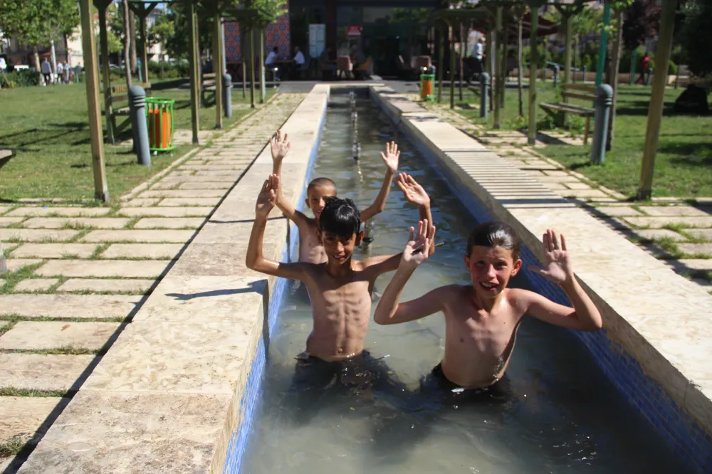 Sıcaktan bunalan çocuklar çözümü süs havuzunda buldu